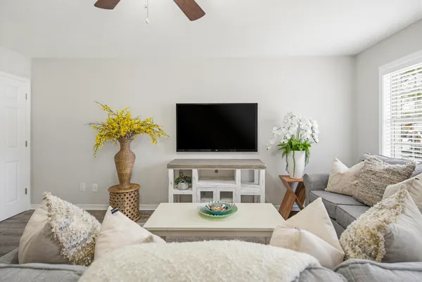 a living room with furniture a flat screen tv and a window