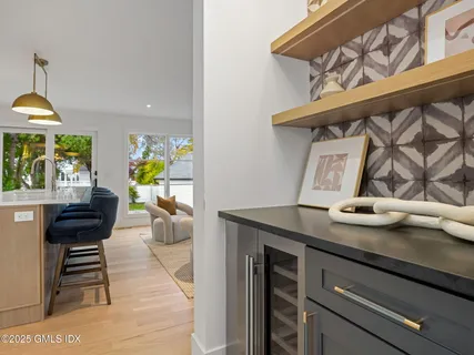 a kitchen with stainless steel appliances kitchen island granite countertop a table chairs and a living room