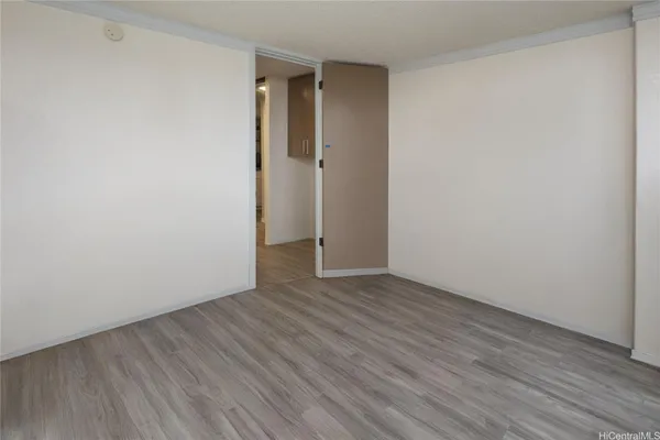 a view of an empty room with wooden floor
