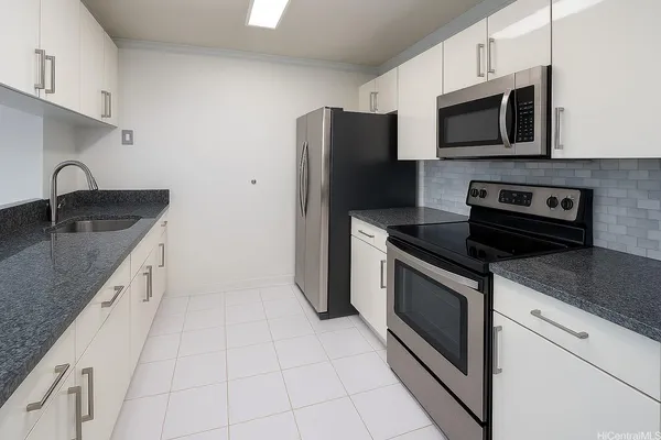 a kitchen with granite countertop a sink stove and refrigerator