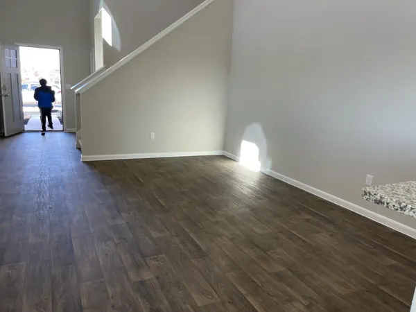 a view of empty room with wooden floor