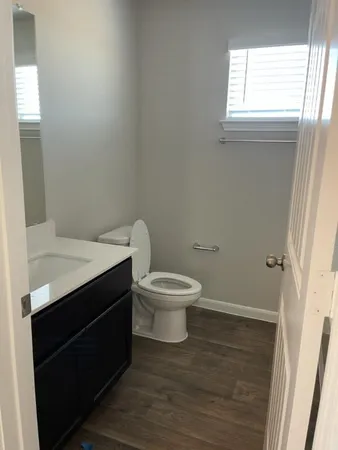 a bathroom with a toilet a sink and a window