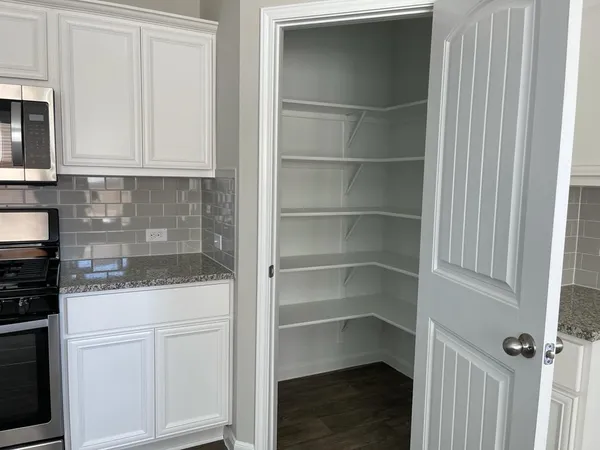 a kitchen with white cabinets and sink