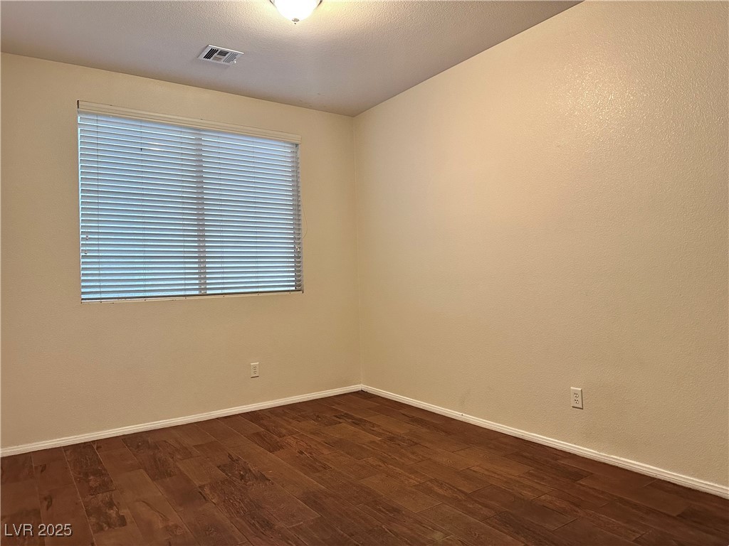 9676 Ridgebluff Avenue Las Vegas, NV 89148 - Photo 3 of 15 Empty room featuring dark wood-type flooring and a textured ceiling