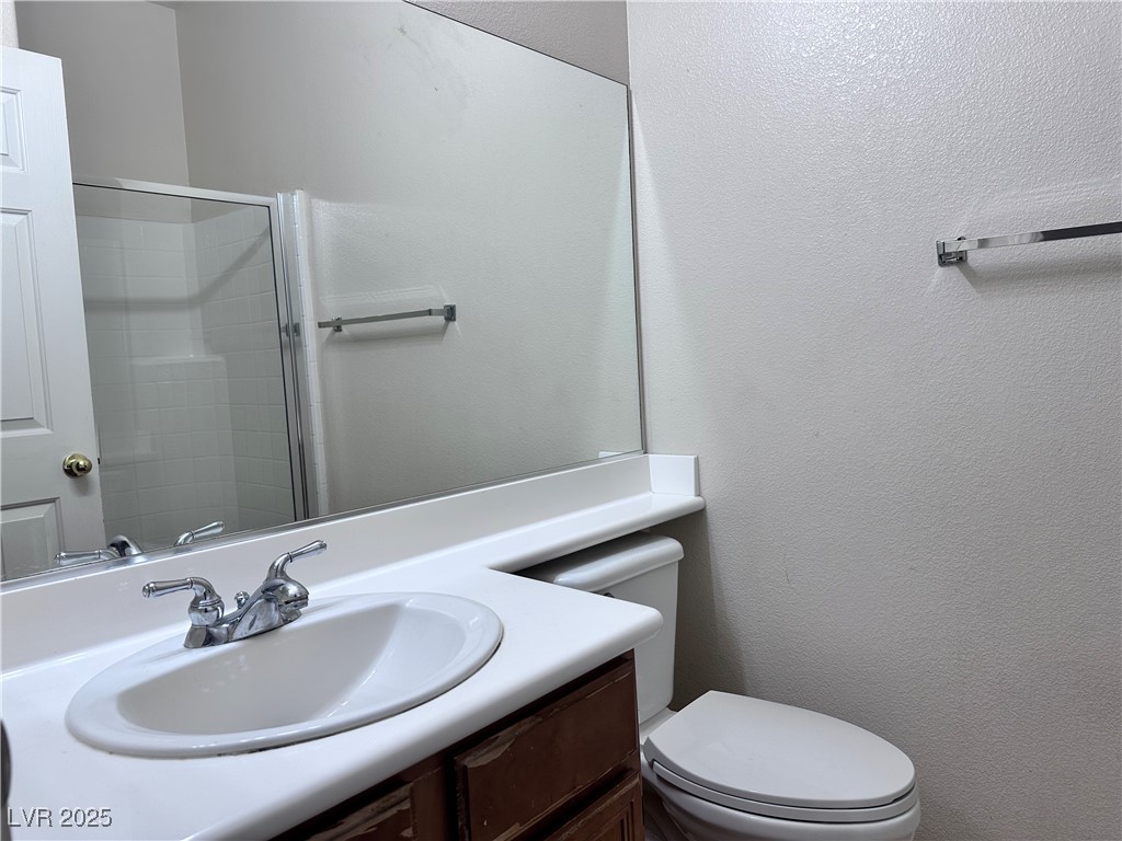 9676 Ridgebluff Avenue Las Vegas, NV 89148 - Photo 8 of 15 Bathroom featuring a textured wall, vanity, and a tile shower