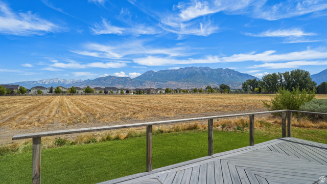111 East Silver Oak Road Vineyard, UT 84059 - Photo 14 of 50 Spacious outdoor deck featuring a patterned wood-finish surface, a wooden railing, and a manicured lawn area