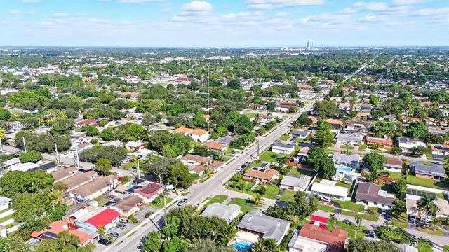 a front view of a house with a garden and trees