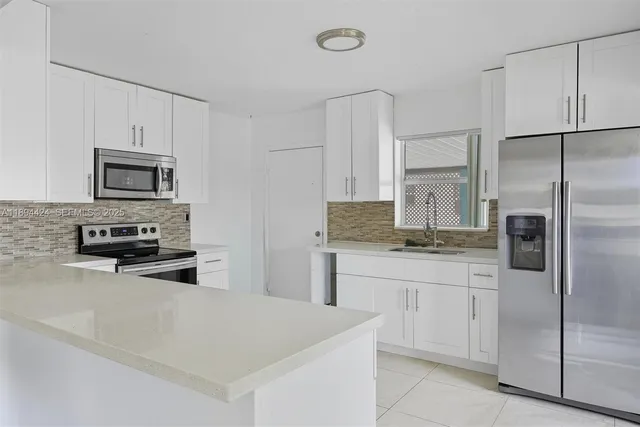 a kitchen with stainless steel appliances a refrigerator sink and microwave