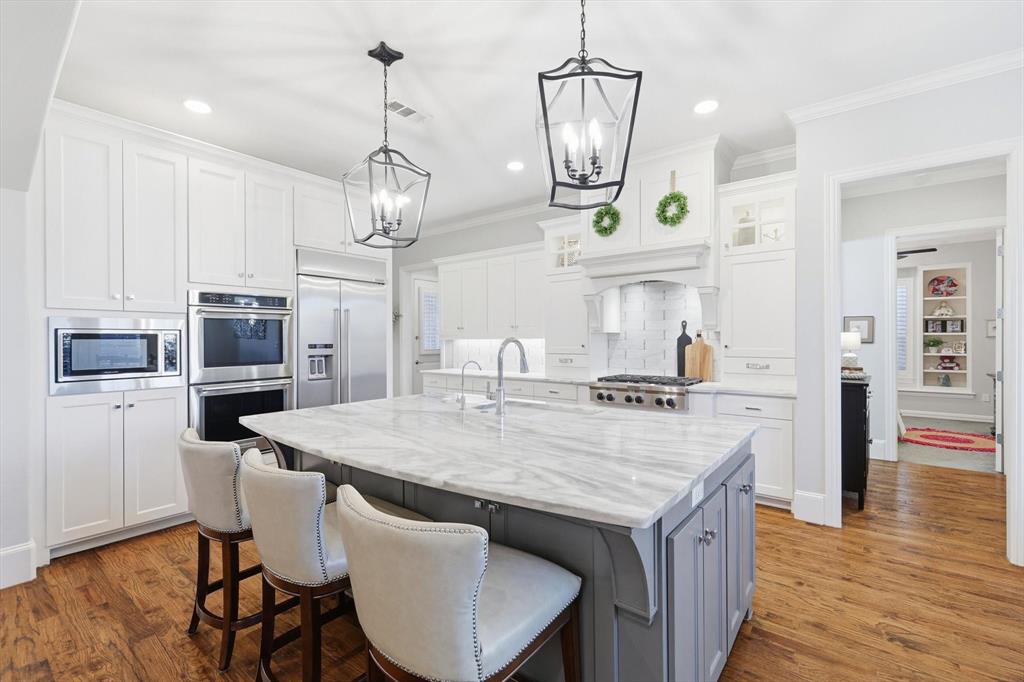 921 Winding Ridge Trail Southlake, TX 76092 - Photo 7 of 40 a open kitchen with stainless steel appliances granite countertop a kitchen island a stove a table and chairs