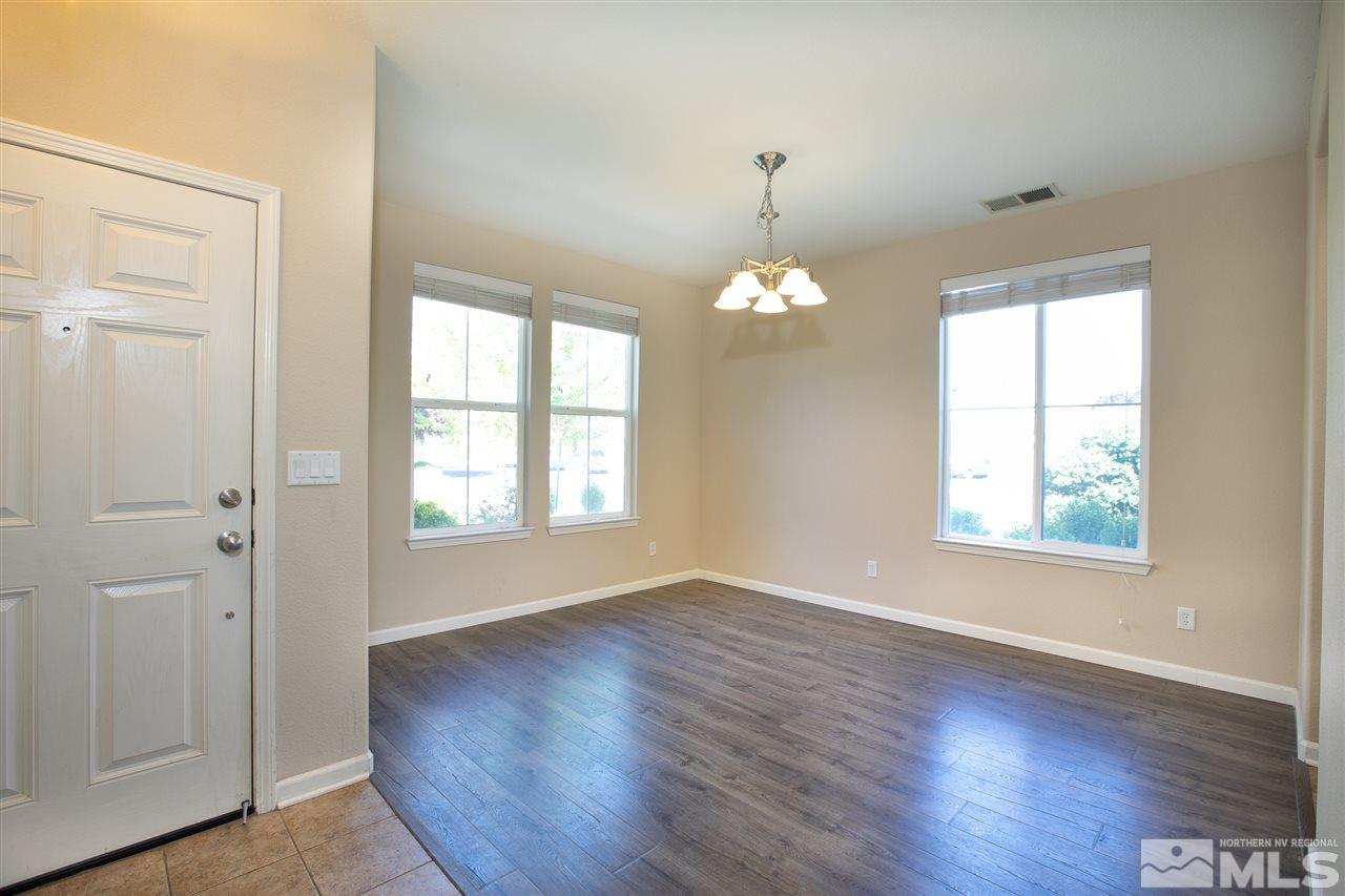 13700 Seabiscuit Drive Reno, NV 89521 - Photo 8 of 27 an empty room with wooden floor chandelier and windows