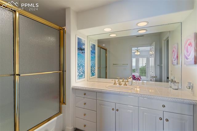 8 Pine Road Colorado Springs, CO 80906 - Photo 5 of 19 Bathroom featuring bath / shower combo with glass door, vanity, and ceiling fan