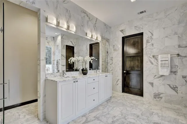 a bathroom with a double vanity sink and a mirror