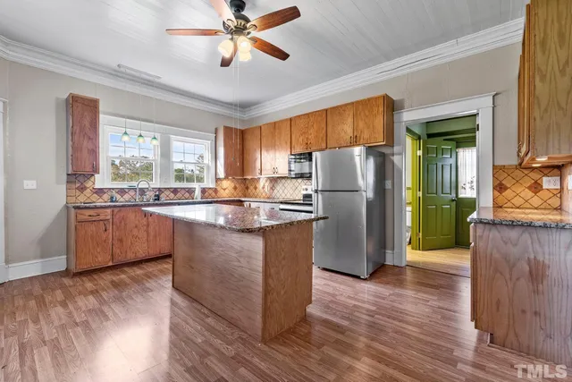 a kitchen with refrigerator cabinets and wooden floor