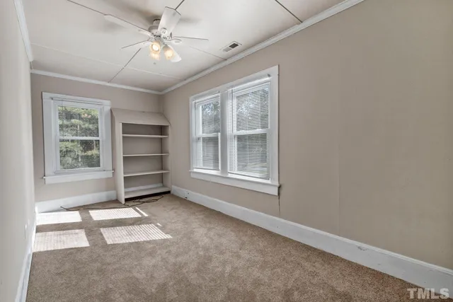 an empty room with windows and cabinet