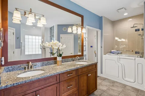 a kitchen with kitchen island granite countertop a sink cabinets and stainless steel appliances