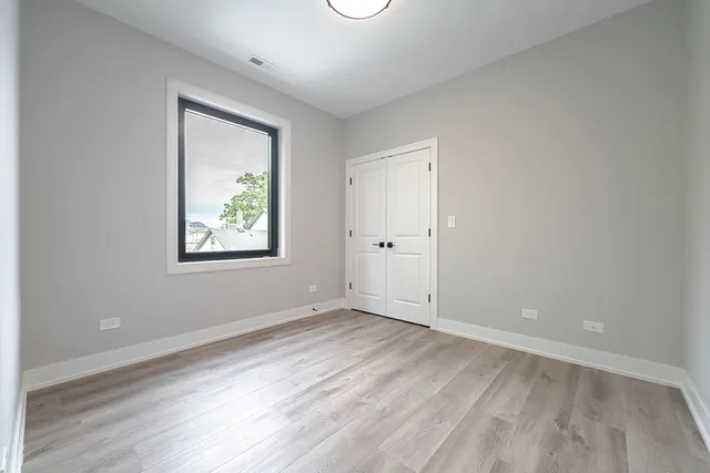 an empty room with a window and wooden floor