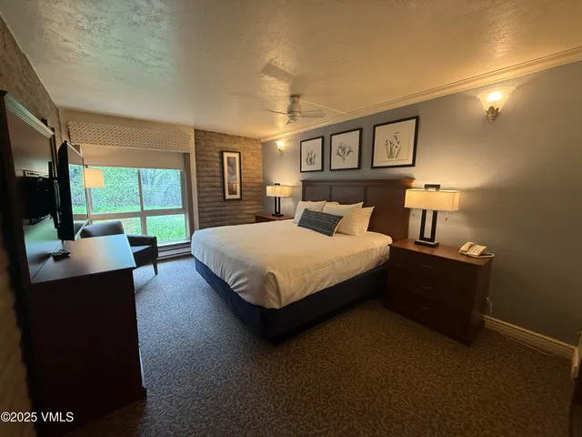 a bedroom with a bed window and a television