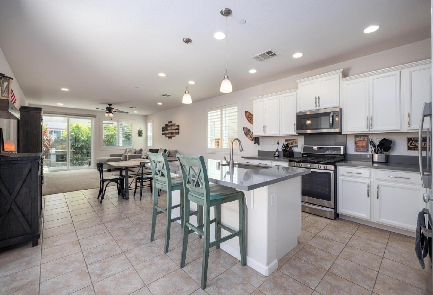 7708 Sumac Place Gilroy, CA 95020 - Photo 6 of 26 a kitchen with stainless steel appliances granite countertop a stove a sink a dining table and chairs