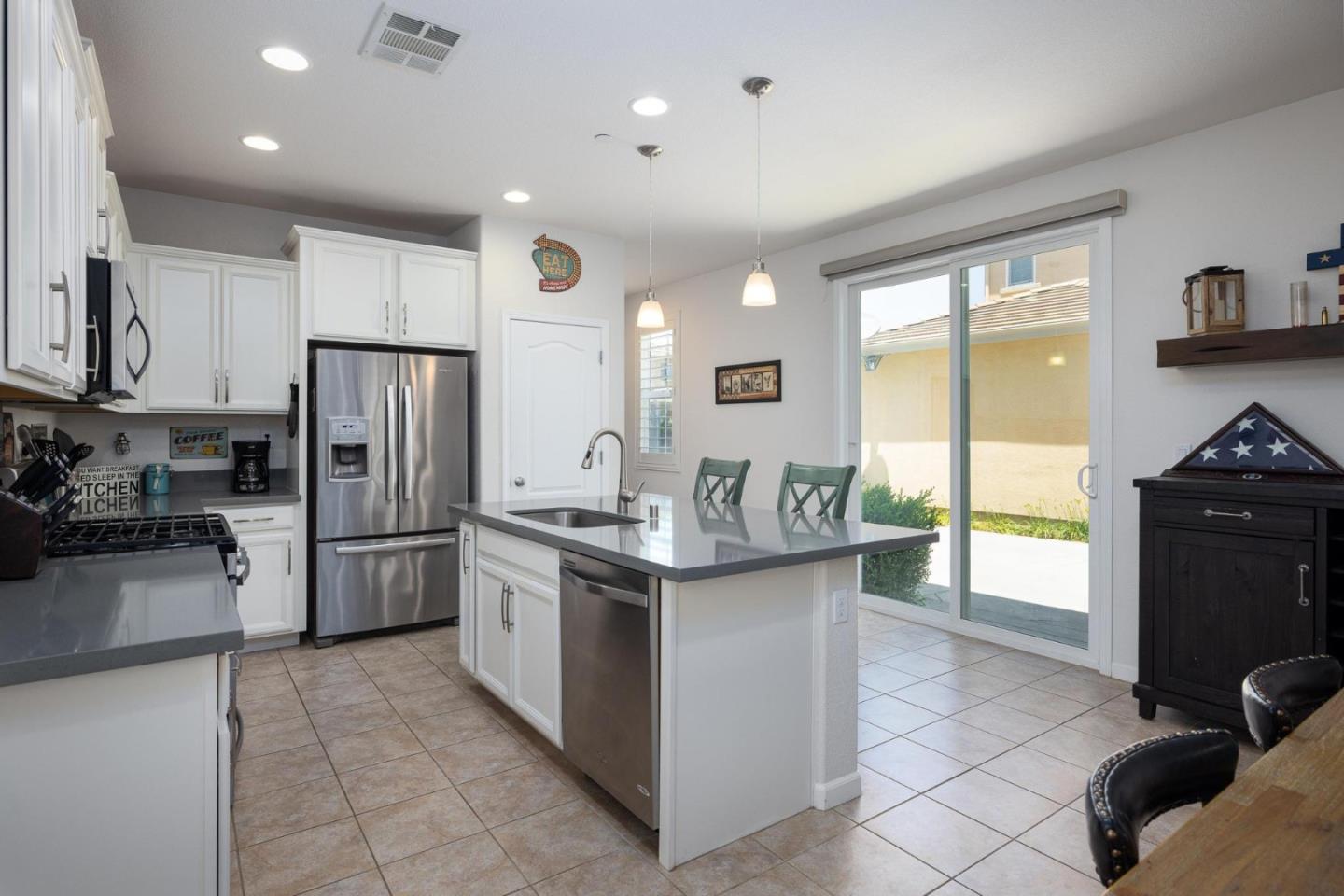 7708 Sumac Place Gilroy, CA 95020 - Photo 8 of 26 a kitchen with stainless steel appliances granite countertop a stove top oven a sink a refrigerator and cabinets