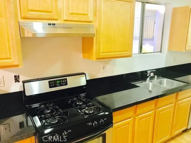 a kitchen with a sink and a stove next to a window