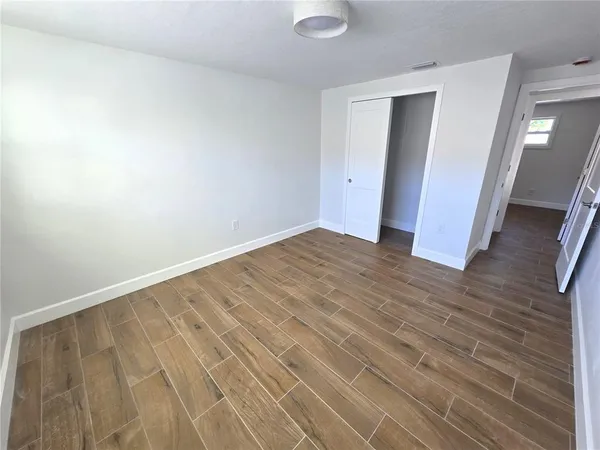a view of an empty room with wooden floor
