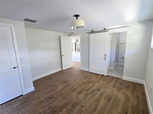 a view of empty room with wooden floor