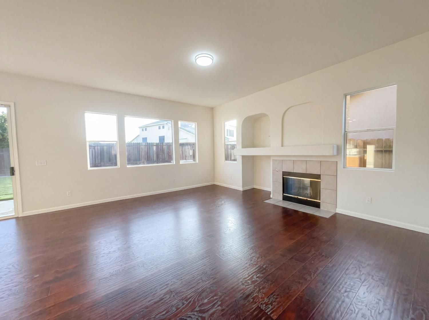 8137 Wyndwillow Way Elk Grove, CA 95758 - Photo 3 of 41 an empty room with wooden floor fireplace and windows