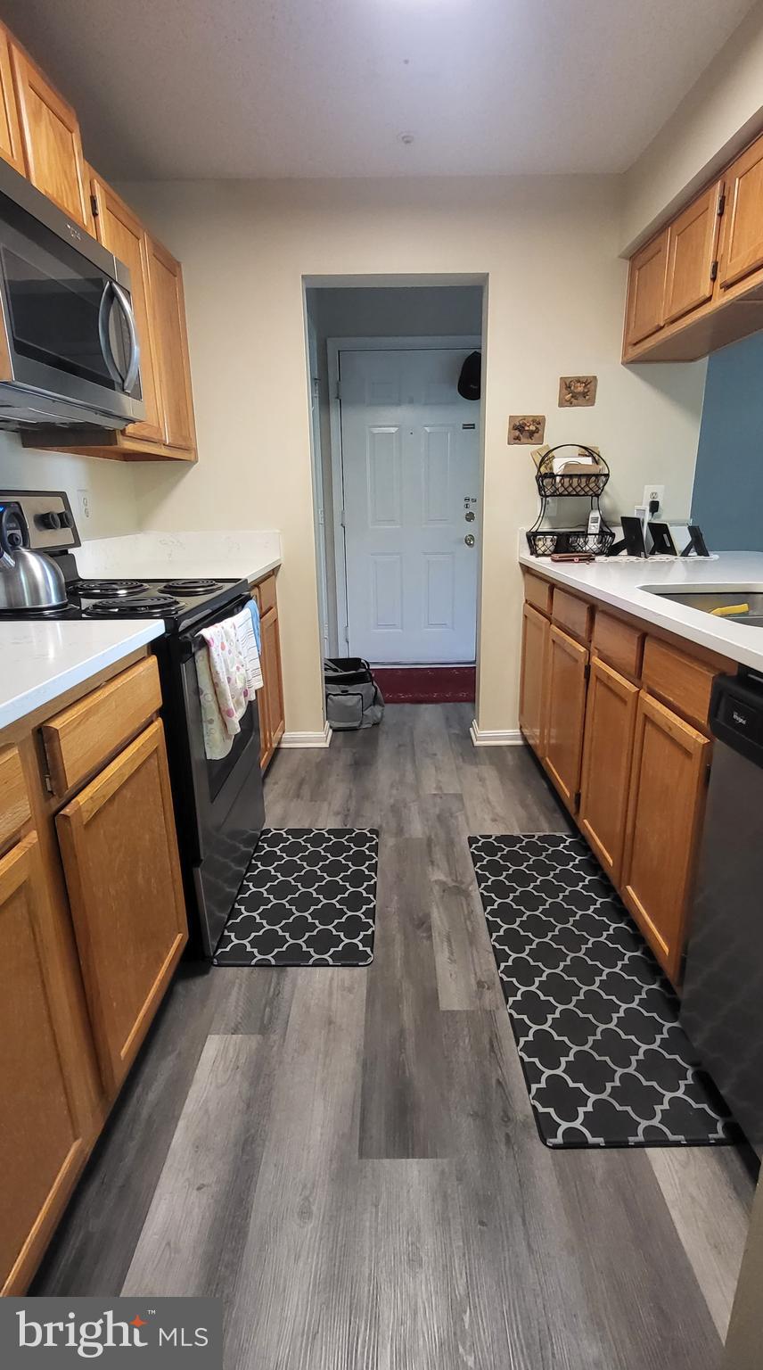 2703 Leaf Drop Court, Unit 817 Silver Spring, MD 20906 - Photo 4 of 16 a kitchen with stainless steel appliances a stove a sink a microwave and cabinets