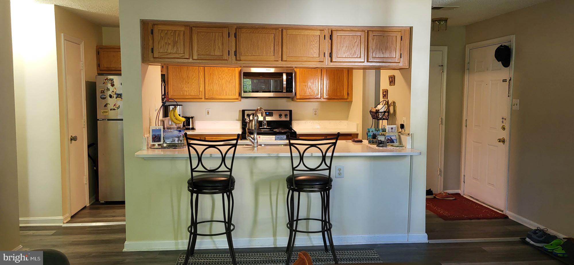2703 Leaf Drop Court, Unit 817 Silver Spring, MD 20906 - Photo 5 of 16 a view of kitchen island with furniture and wooden floor