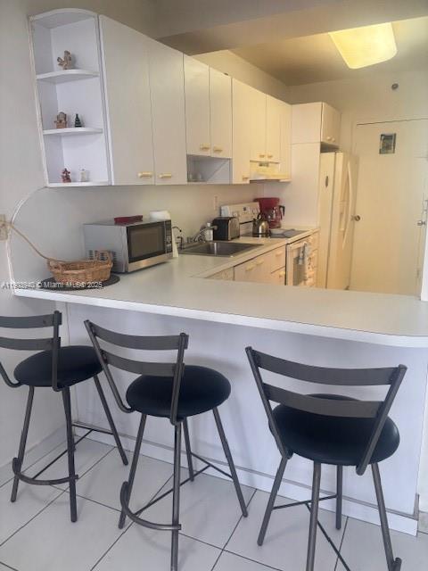 100 Lincoln Road, Unit 1030 Miami Beach, FL 33139 - Photo 6 of 35 a kitchen with stainless steel appliances kitchen island a table chair and a refrigerator