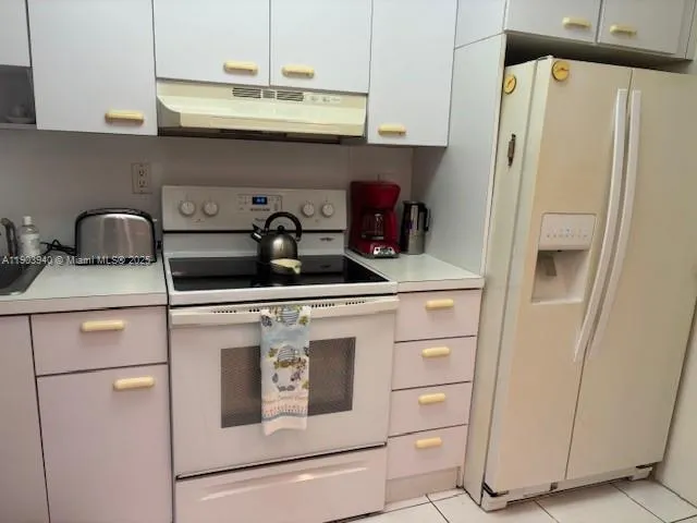 a kitchen with appliances a refrigerator and cabinets
