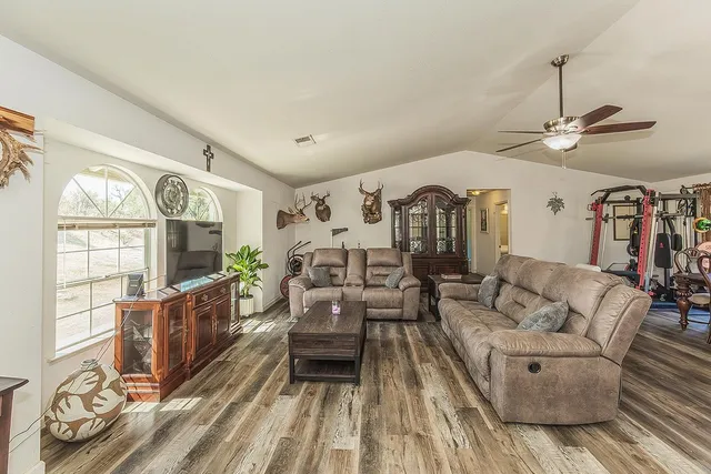 a living room with furniture a dining table and a flat screen tv