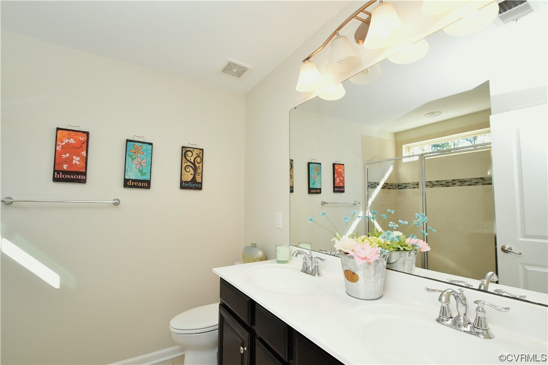 5509 Riverside Heights Way Richmond, VA 23225 - Photo 15 of 28 a bathroom with a sink vanity mirror and toilet