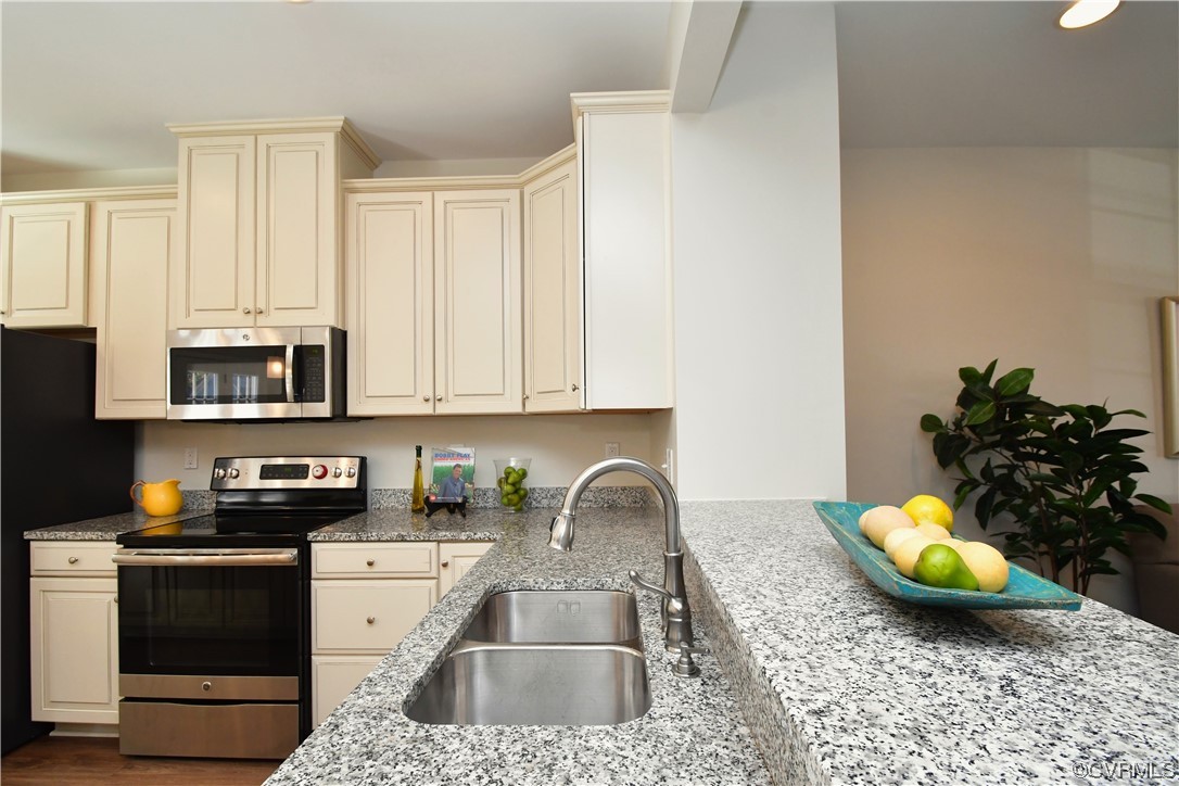 5509 Riverside Heights Way Richmond, VA 23225 - Photo 6 of 28 a kitchen with a sink a stove and cabinets