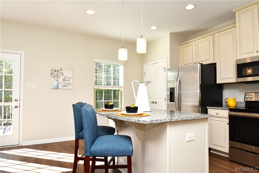 5509 Riverside Heights Way Richmond, VA 23225 - Photo 7 of 28 a kitchen with stainless steel appliances granite countertop a dining table chairs and a refrigerator