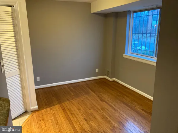 a view of a room with wooden floor and small window