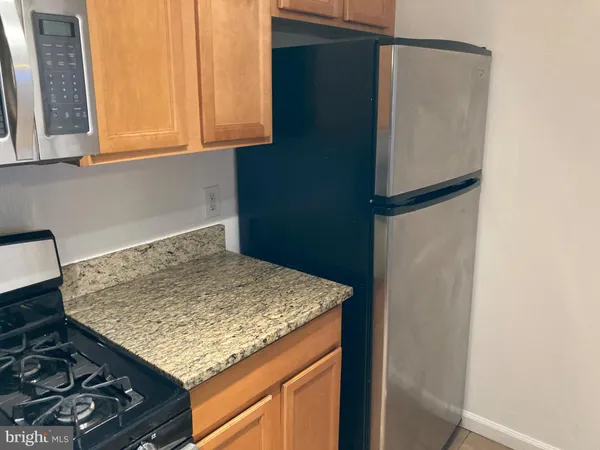 a kitchen with kitchen island a stove and a refrigerator