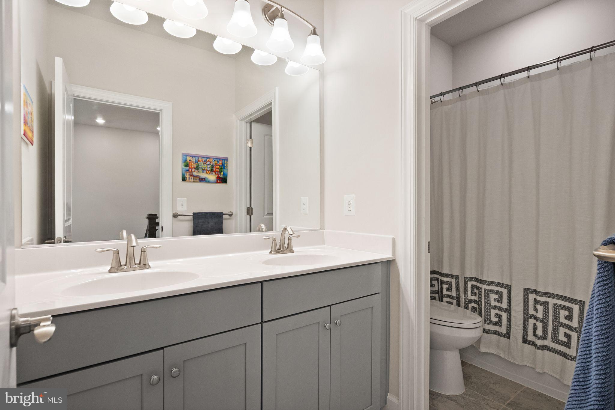 9516 Sanger Street Lorton, VA 22079 - Photo 31 of 45 a bathroom with a double vanity sink mirror and toilet
