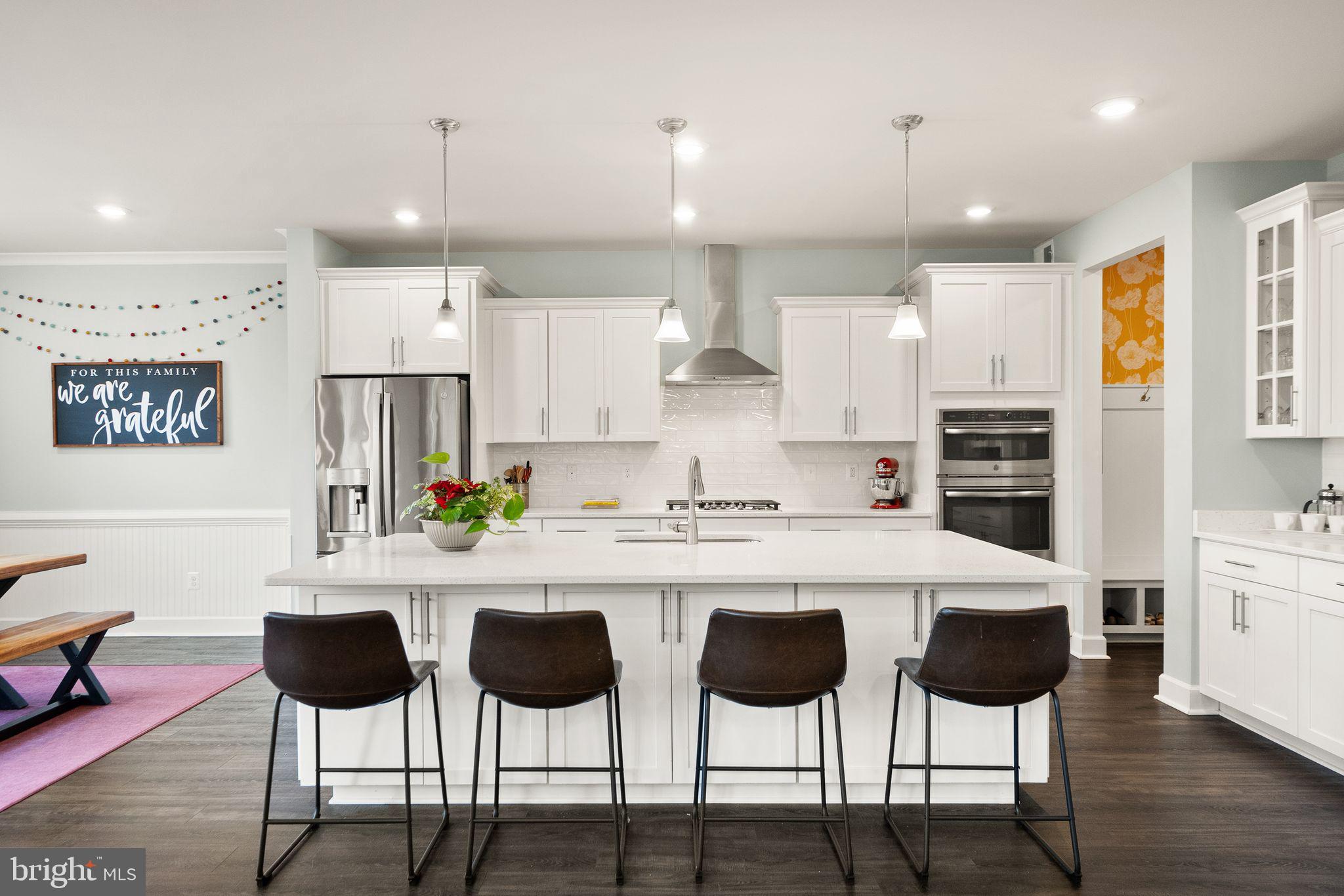 9516 Sanger Street Lorton, VA 22079 - Photo 8 of 45 a kitchen with stainless steel appliances kitchen island granite countertop a dining table chairs and white cabinets