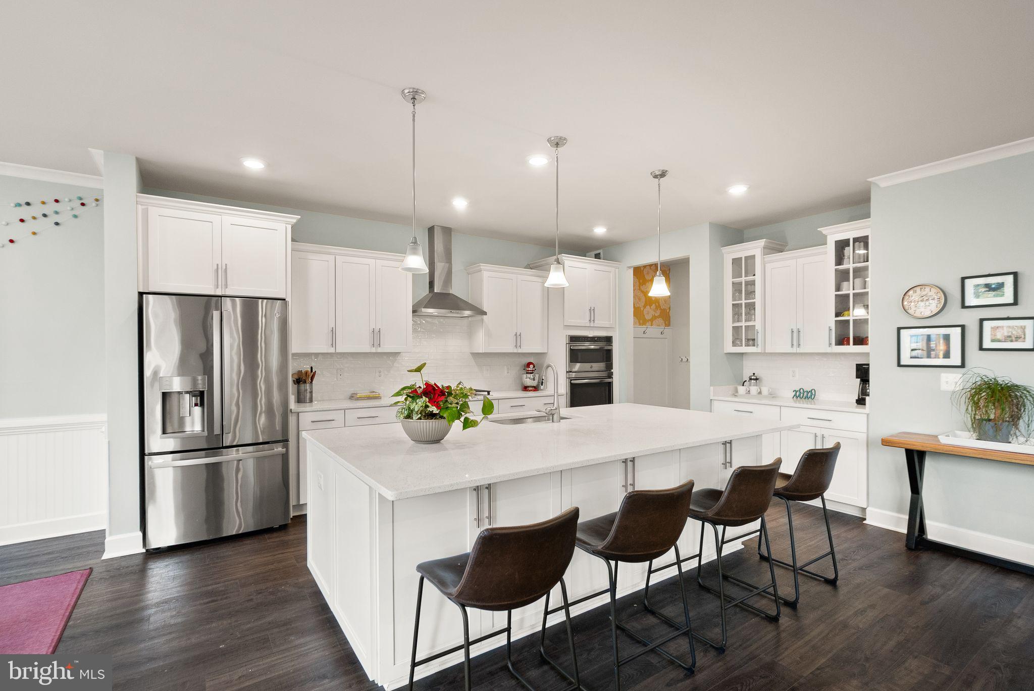 9516 Sanger Street Lorton, VA 22079 - Photo 9 of 45 a kitchen with a refrigerator a dining table and chairs