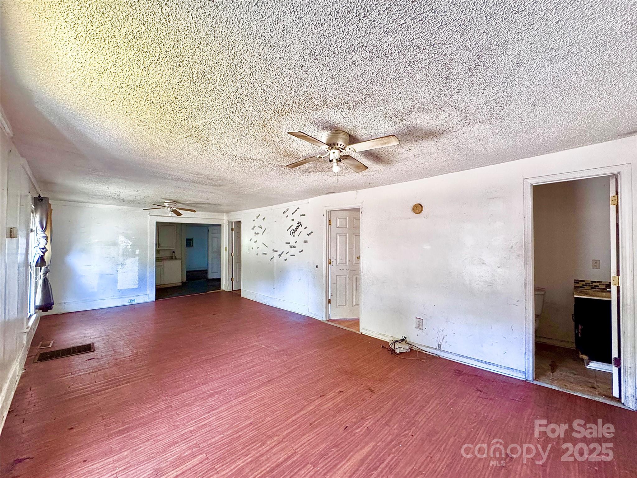 615 Fairview Street Kannapolis, NC 28083 - Photo 3 of 8 an empty room with wooden floor and windows