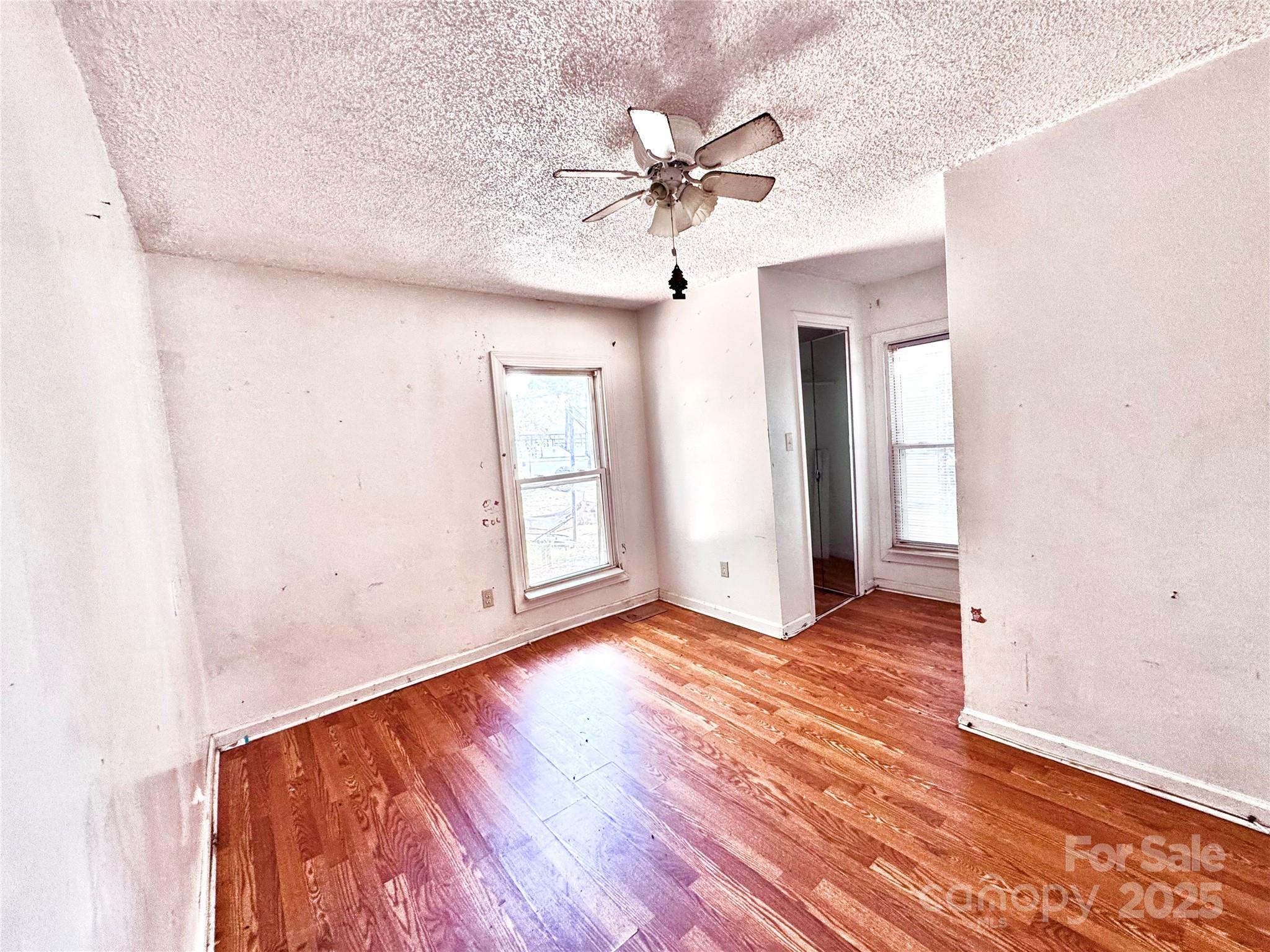 615 Fairview Street Kannapolis, NC 28083 - Photo 4 of 8 an empty room with wooden floor fan and windows