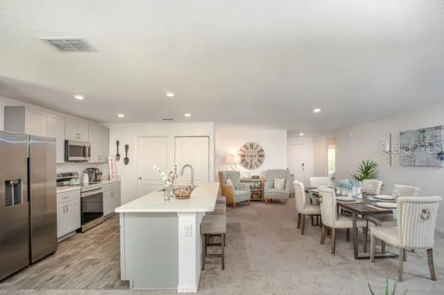 a kitchen with a sink white cabinets and stainless steel appliances