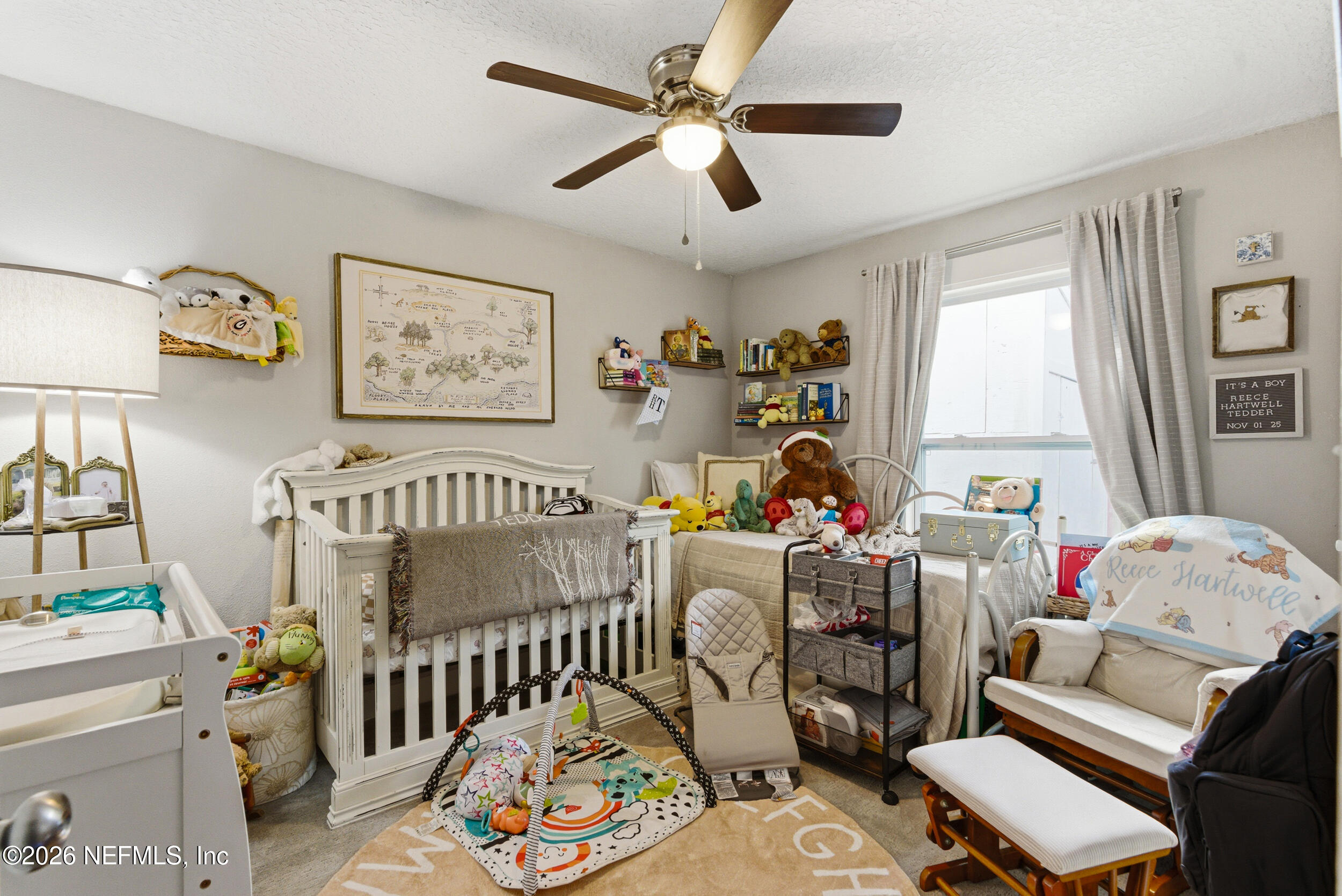 5188 Tan Street Jacksonville, FL 32258 - Photo 16 of 24 a bedroom with furniture a baby bed a couch and a window