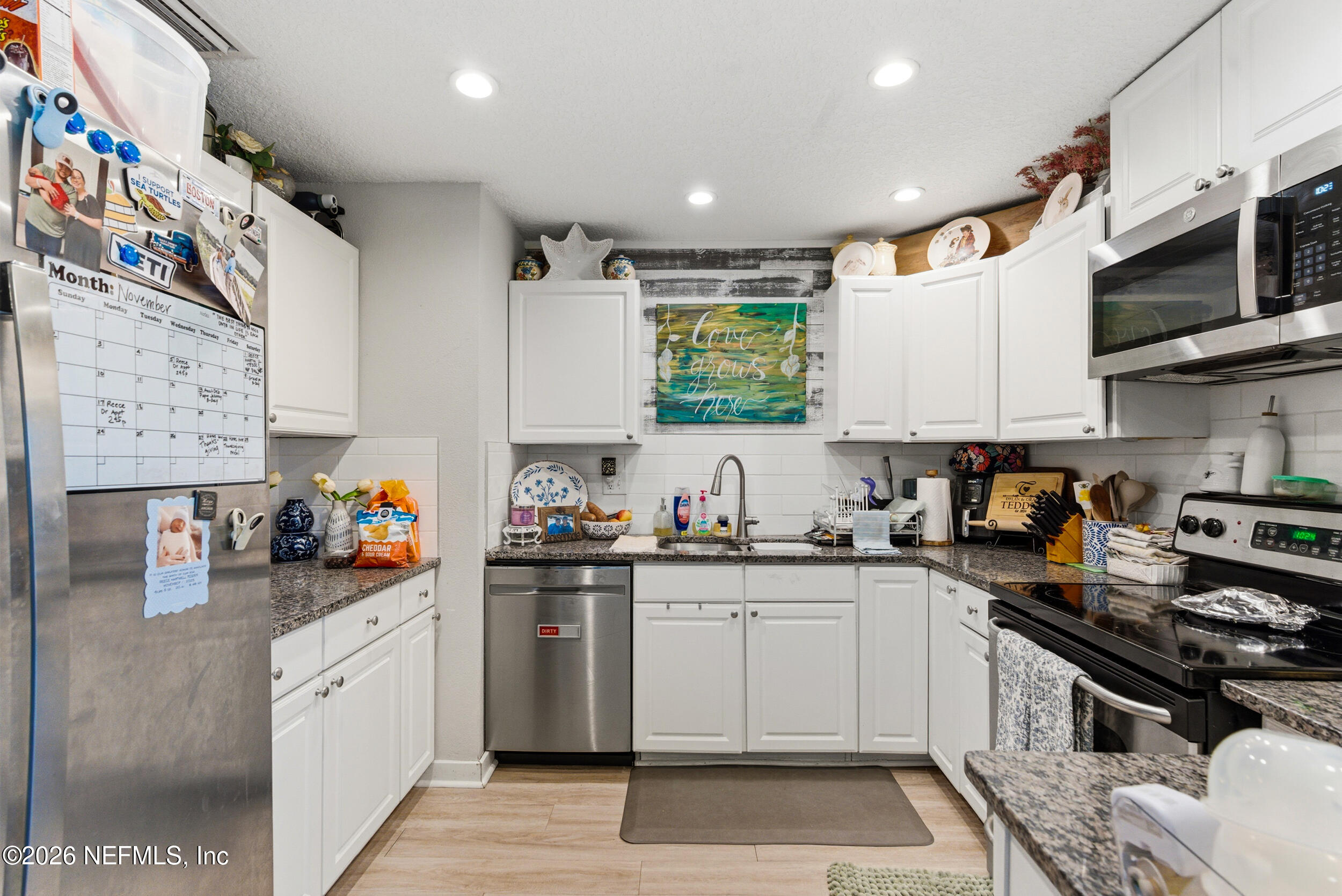 5188 Tan Street Jacksonville, FL 32258 - Photo 10 of 24 a kitchen with stainless steel appliances a sink dishwasher a stove and white cabinets