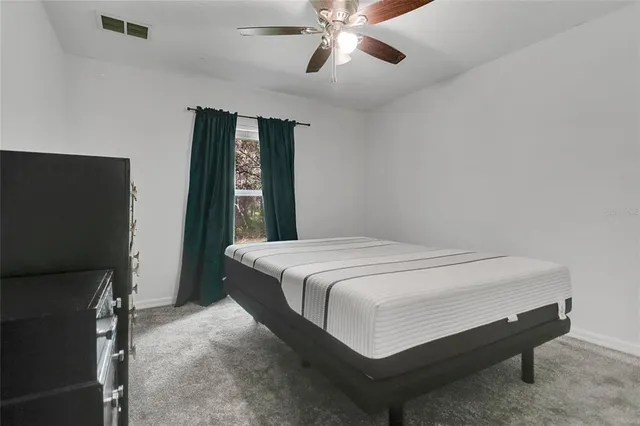 a bed sitting in a bedroom next to a window