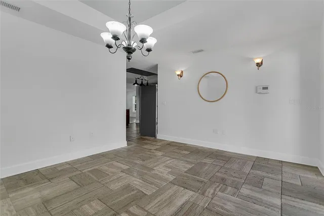 a view of a room with wooden floor and chandelier
