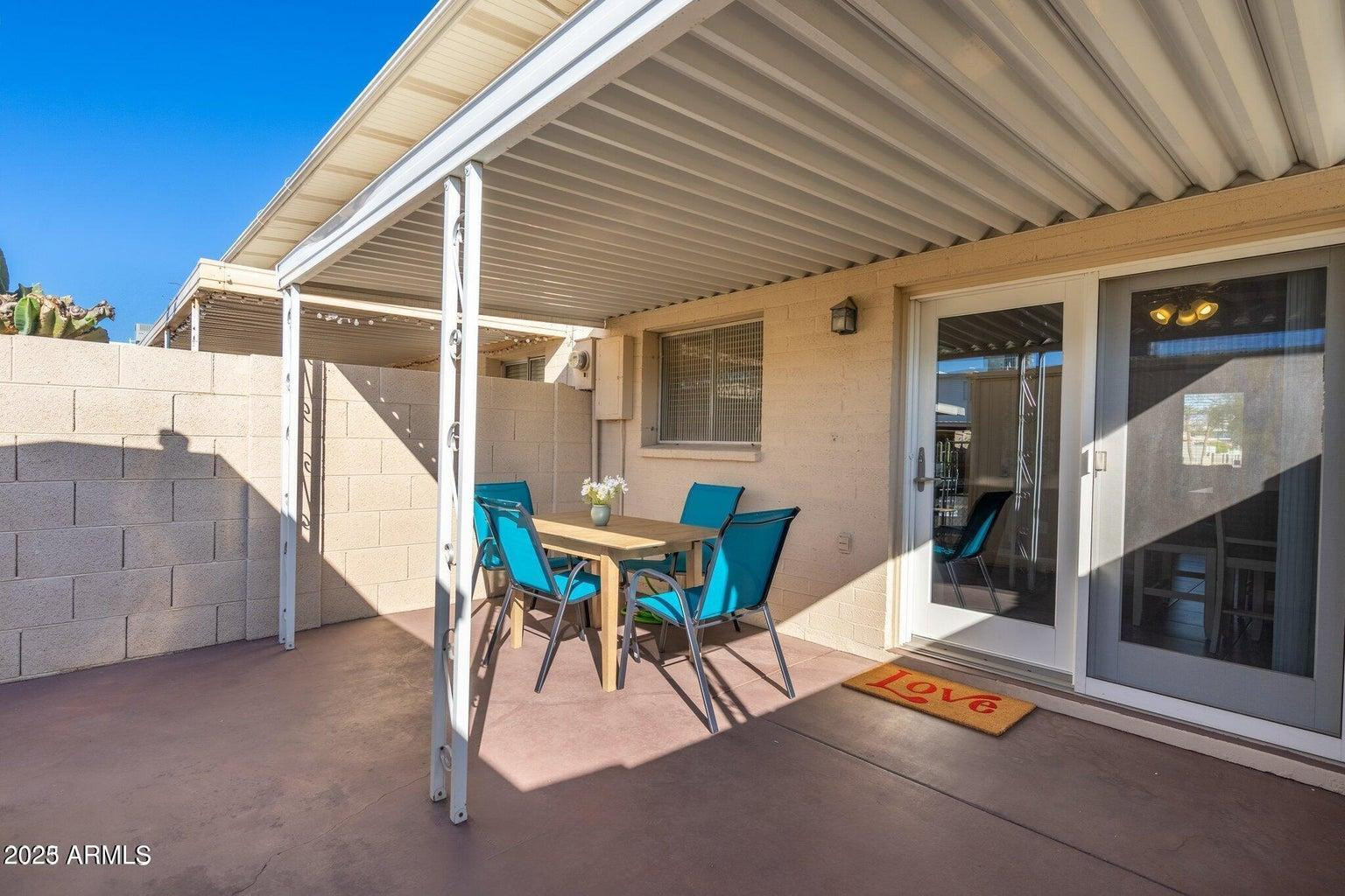 6921 East Osborn Road, Unit D Scottsdale, AZ 85251 - Photo 11 of 13 a patio with table and chairs and potted plants