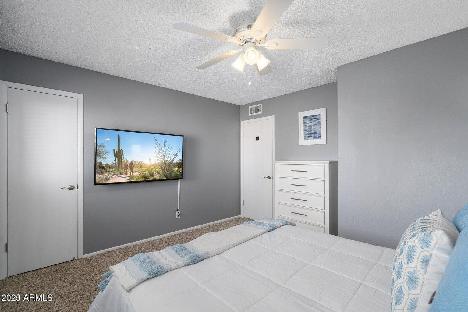 6921 East Osborn Road, Unit D Scottsdale, AZ 85251 - Photo 12 of 13 a bedroom with a bed and a flat screen tv
