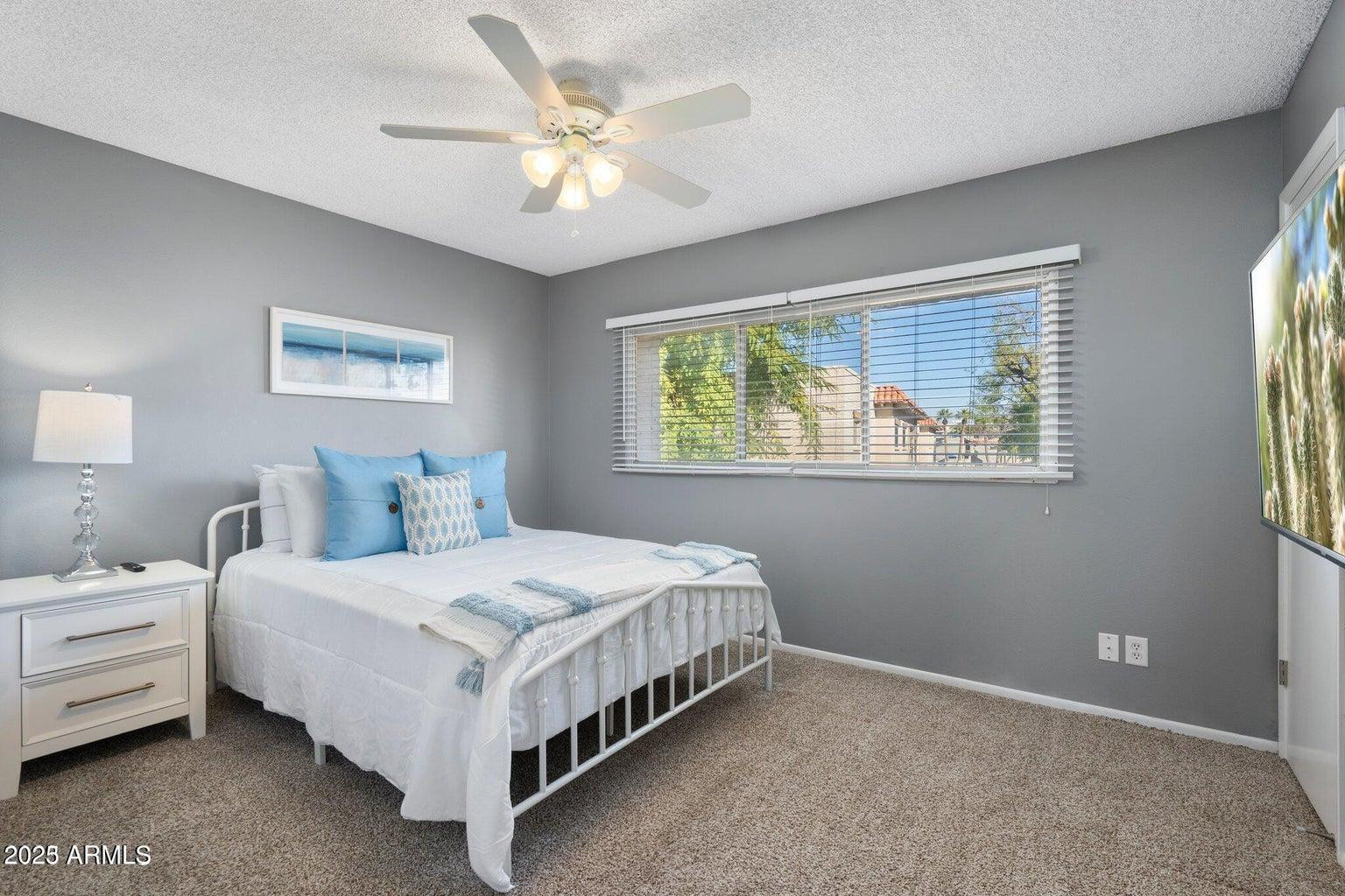 6921 East Osborn Road, Unit D Scottsdale, AZ 85251 - Photo 13 of 13 a bedroom with a bed lamp and window